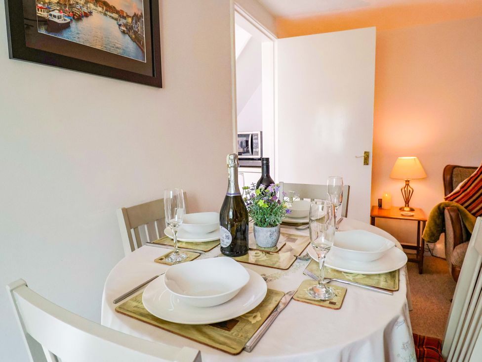 A dining table with plates and drinks at Poppy Cottage in Charlton Marshall