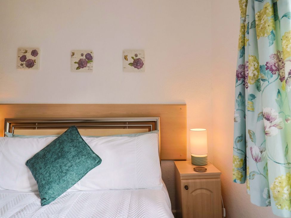 A bedroom with a bed and bedside table at Poppy Cottage Charlton Marshall