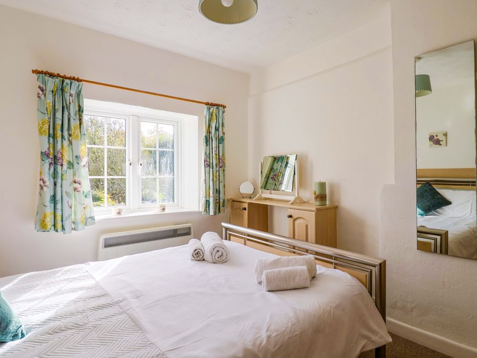 A bedroom with a bed and dresser at Poppy Cottage in Charlton Marshall