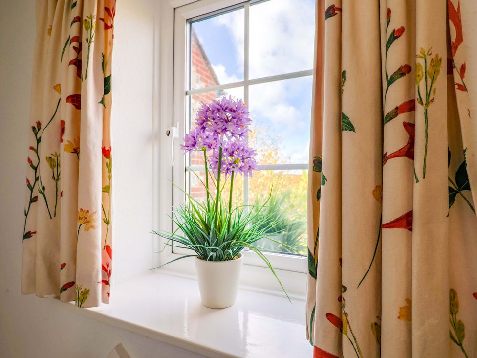 A window with a flowerpot at Poppy Cottage in Charlton Marshall