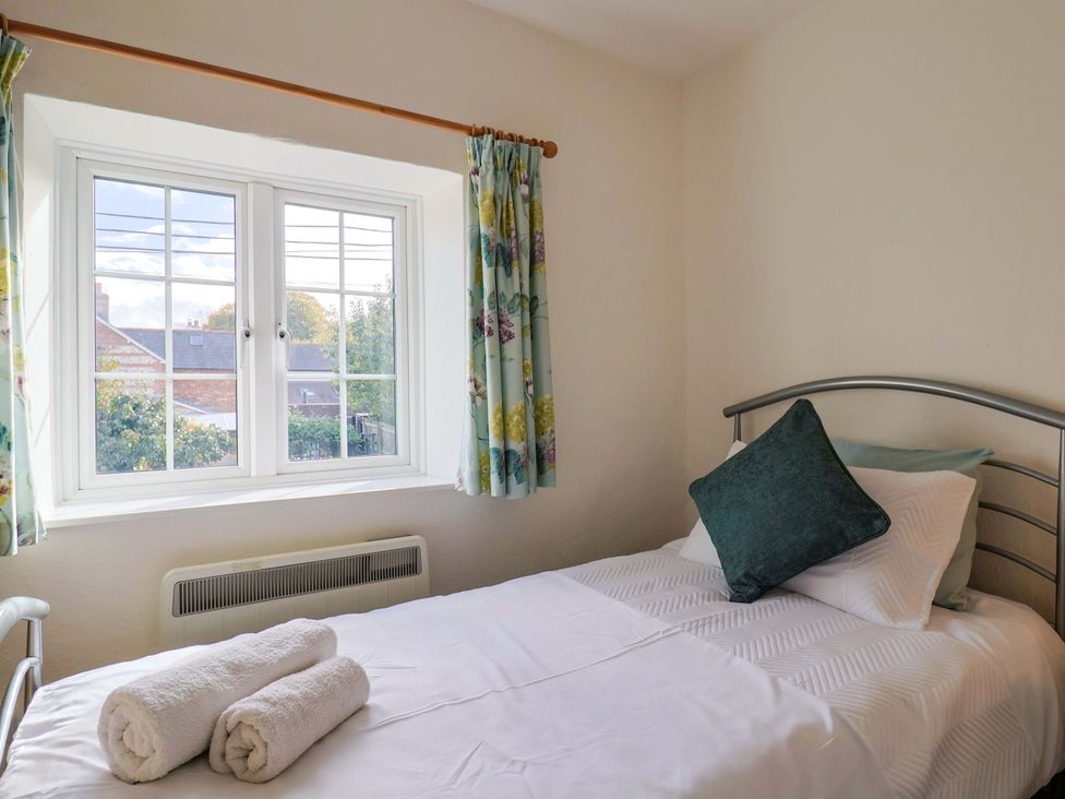A bedroom with a bed and window at Poppy Cottage in Charlton Marshall