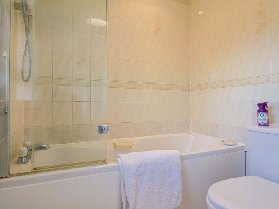 A bathroom with a bath tub and shower at Poppy Cottage in Charlton Marshall