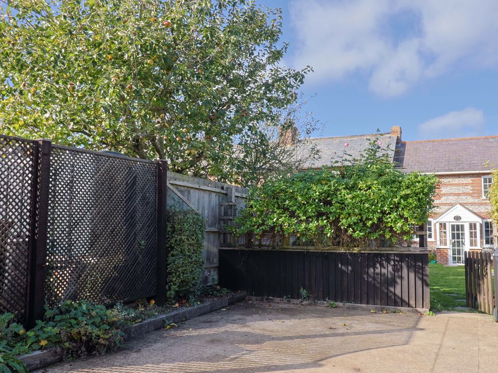 A garden with a tree and a wooden fence at Poppy Cottage Charlton Marshall