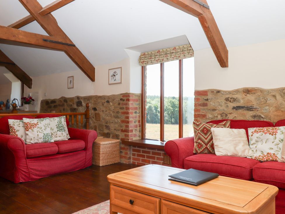 A living room with sofas and a coffee table at The Cottage in Sampford Courtenay