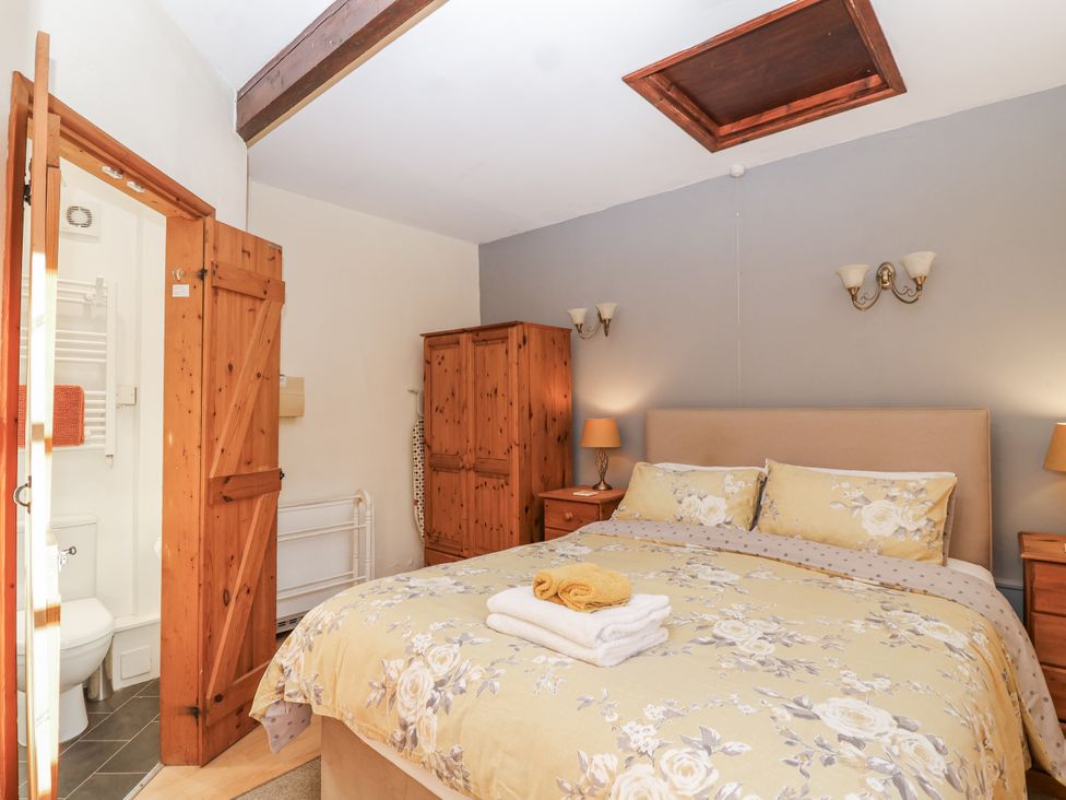 A bedroom with a bed and wardrobe at Miners Dry in Gulworthy, near Tavistock