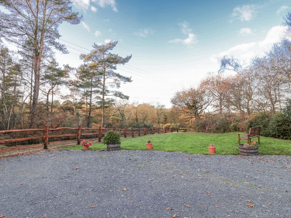 An outdoor area with trees, a bench, and gravel at Miners Dry, Gulworthy, near Tavistock