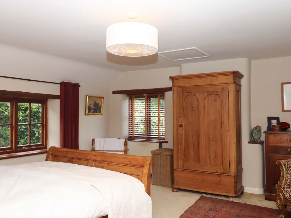 A bedroom with a bed and wardrobe at Hope Cottage in Riddlecombe, near Winkleigh