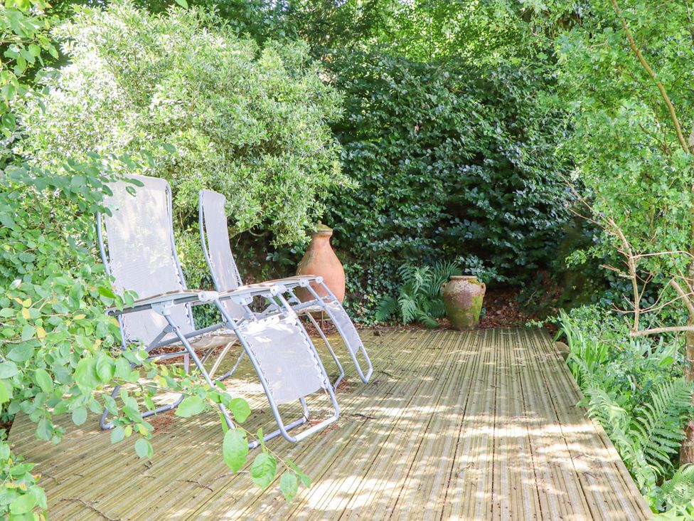 A garden area with lounge chairs and planters at Hope Cottage in Riddlecombe, near Winkleigh