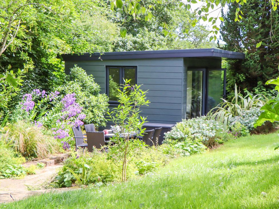 A garden with a shed and outdoor seating at Hope Cottage, Riddlecombe, near Winkleigh