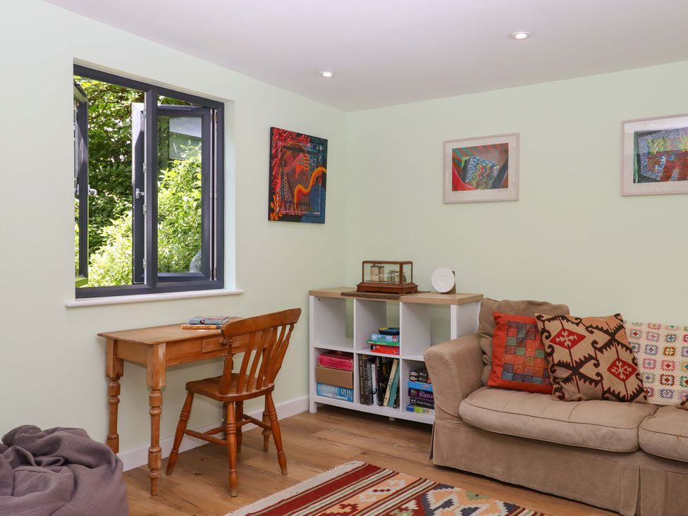 A living room with a table and chair at Hope Cottage in Riddlecombe, near Winkleigh