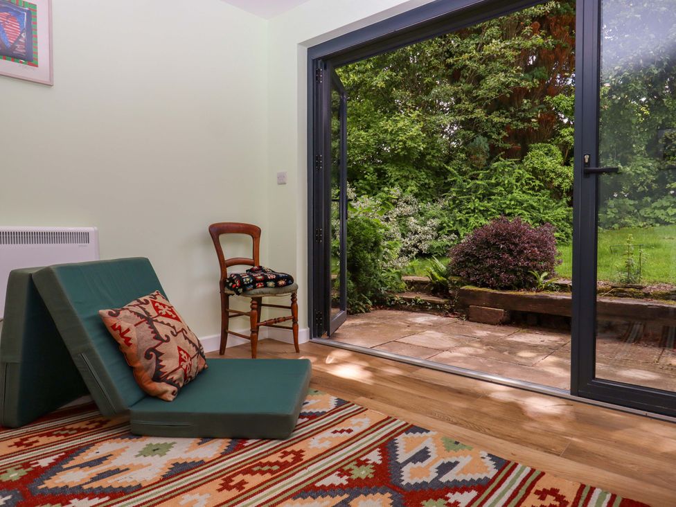 A snug with a folding chair and rug at Hope Cottage in Riddlecombe, near Winkleigh
