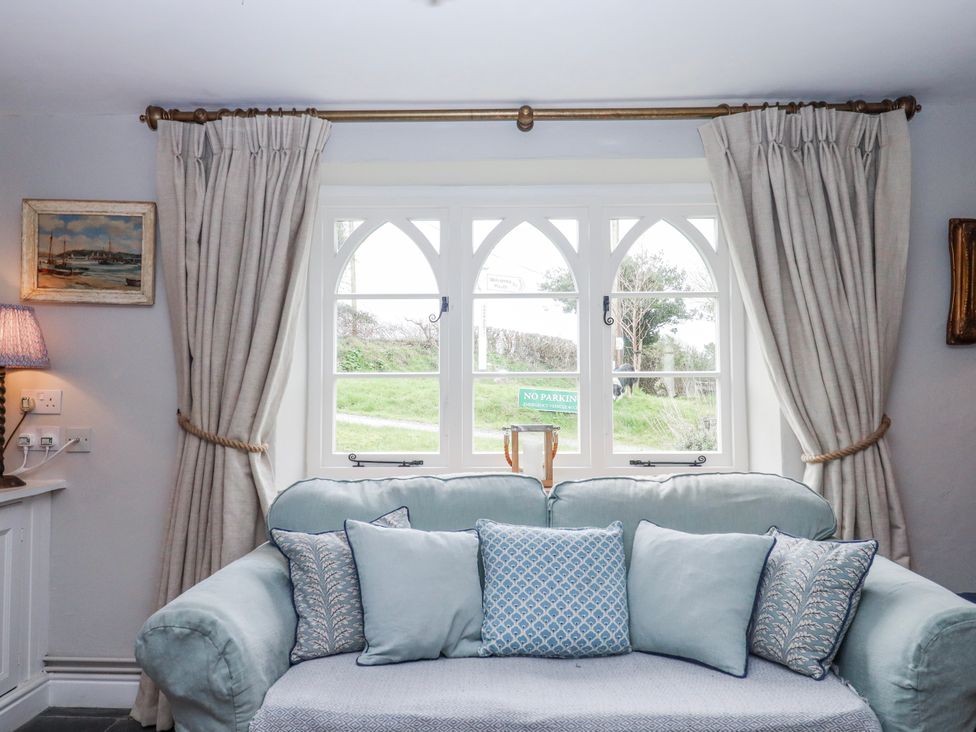 A living room with a sofa and cushions at Chapel Cottage in Welcombe