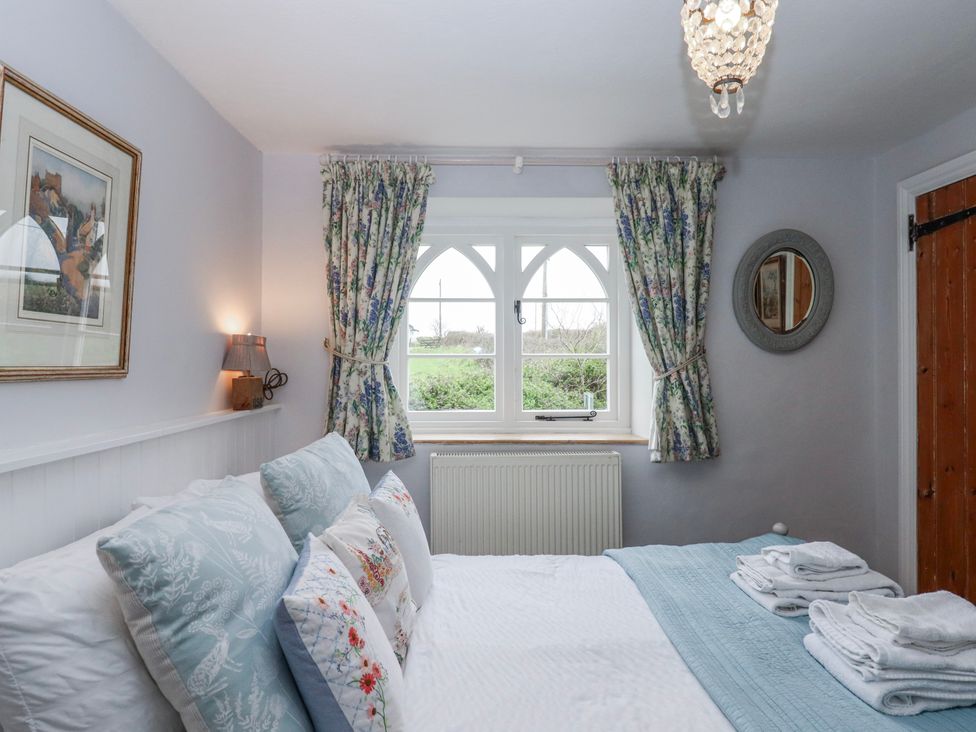 A bedroom with a bed and window at Chapel Cottage in Welcombe