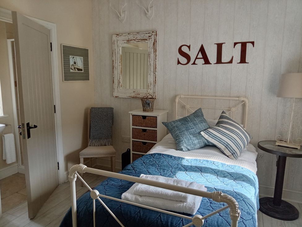 A bedroom with a bed and decorative items at Saltwind Granary in Clovelly
