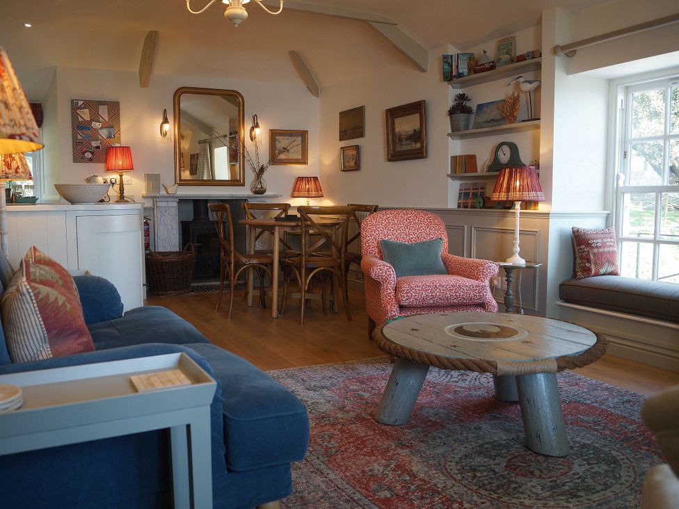 A living room with a dining table and chairs at Coach House Cottage, Strete, near Dartmouth