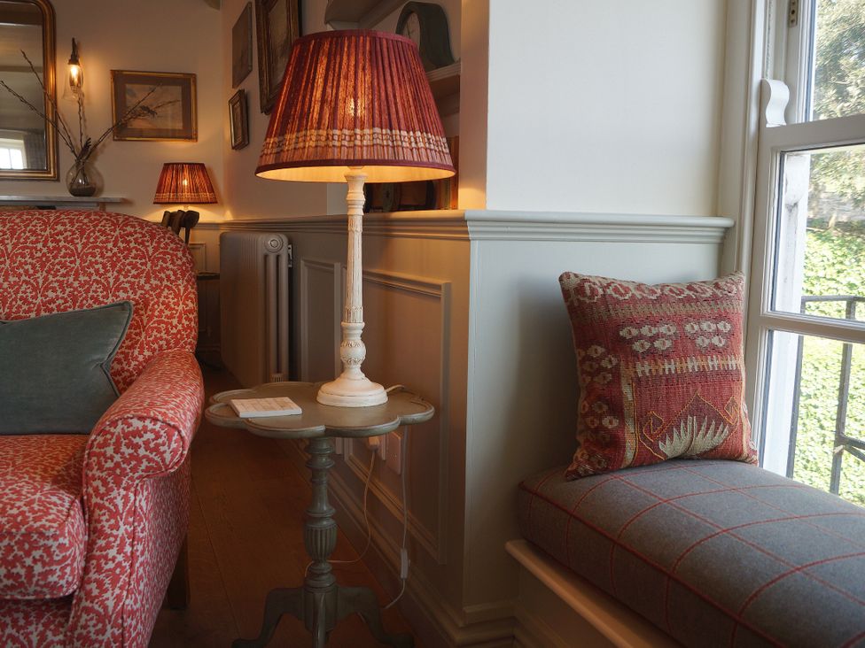 A living room with a sofa, lamp, and side table at Coach House Cottage, Strete, near Dartmouth