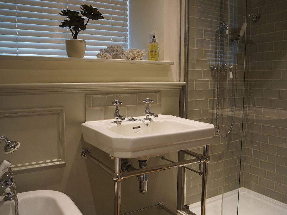 A bathroom with a sink, shower and toilet at Coach House Cottage in Strete, near Dartmouth