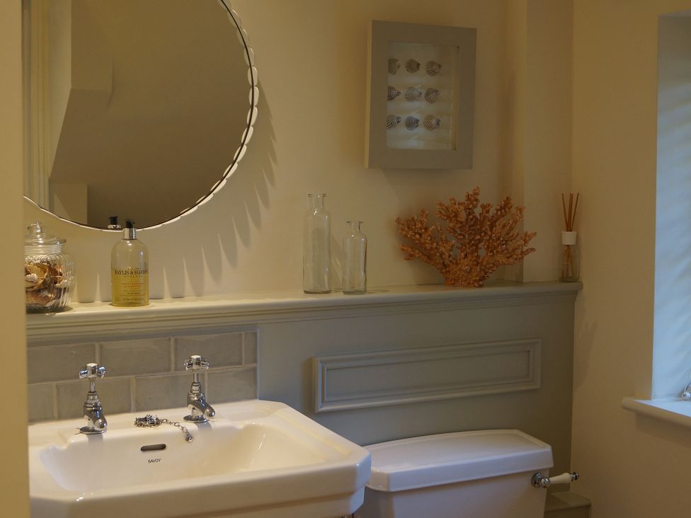 A bathroom with a sink and toilet at Coach House Cottage in Strete, near Dartmouth