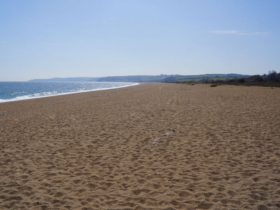 A beach with sand and ocean at Coach House Cottage, Strete, near Dartmouth