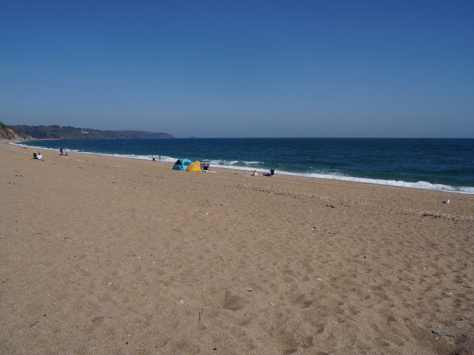 A beach with people and tents at Coach House Cottage in Strete, near Dartmouth