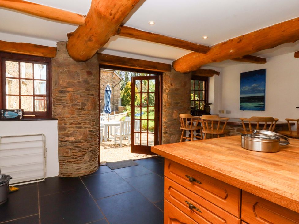 A kitchen with wooden beams and a door leading to the garden at East Bickleigh Halwell