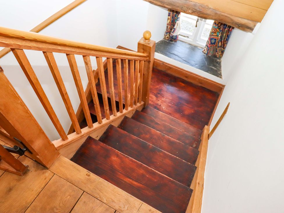 A stairwell with wooden staircase leading to a window at East Bickleigh Halwell