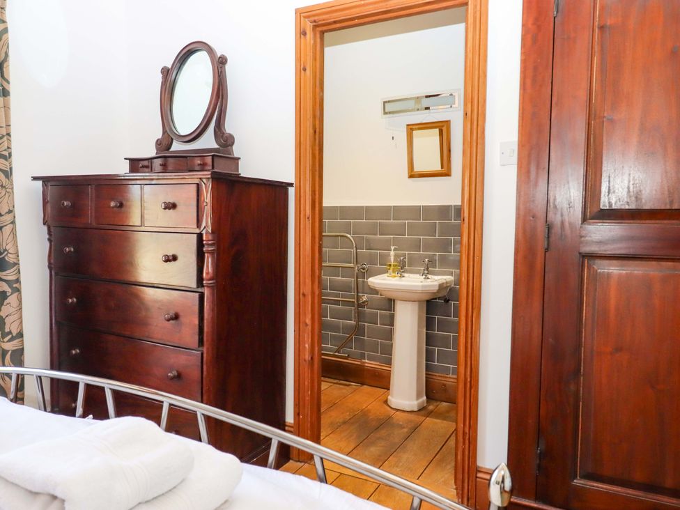 A bedroom with a dresser and a doorway to a bathroom at East Bickleigh in Halwell
