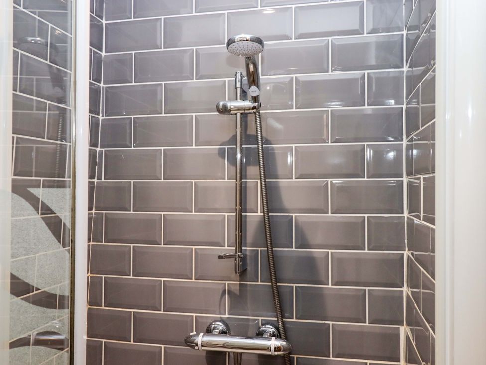 A shower with tiled wall and showerhead at East Bickleigh Halwell