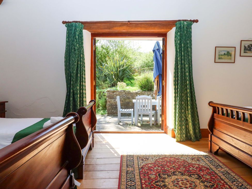 A bedroom with two beds and an outdoor view at East Bickleigh in Halwell