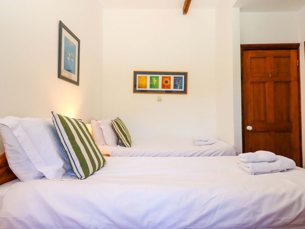 A bedroom with two beds and artwork on the wall at East Bickleigh in Halwell