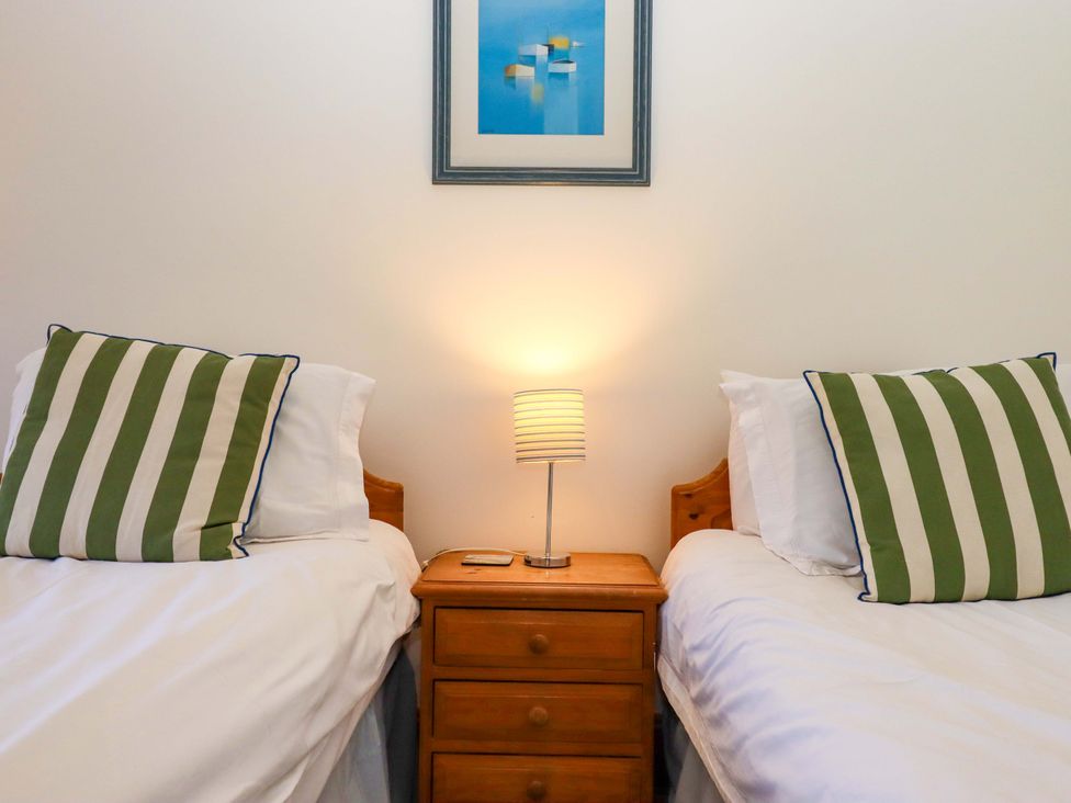 A bedroom with two beds and a lamp on a nightstand at East Bickleigh Halwell
