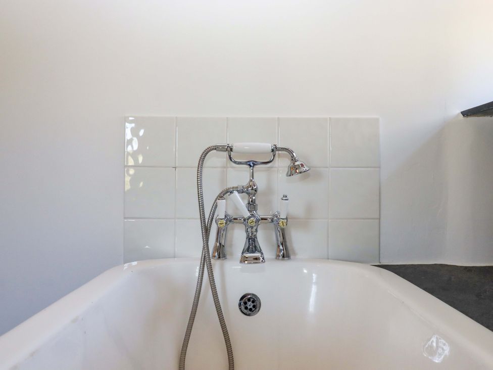A bathtub with faucet and showerhead at East Bickleigh Halwell