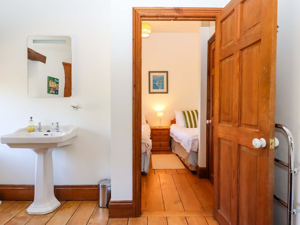 A bedroom with a hand basin and a doorway leading to another room at East Bickleigh Halwell