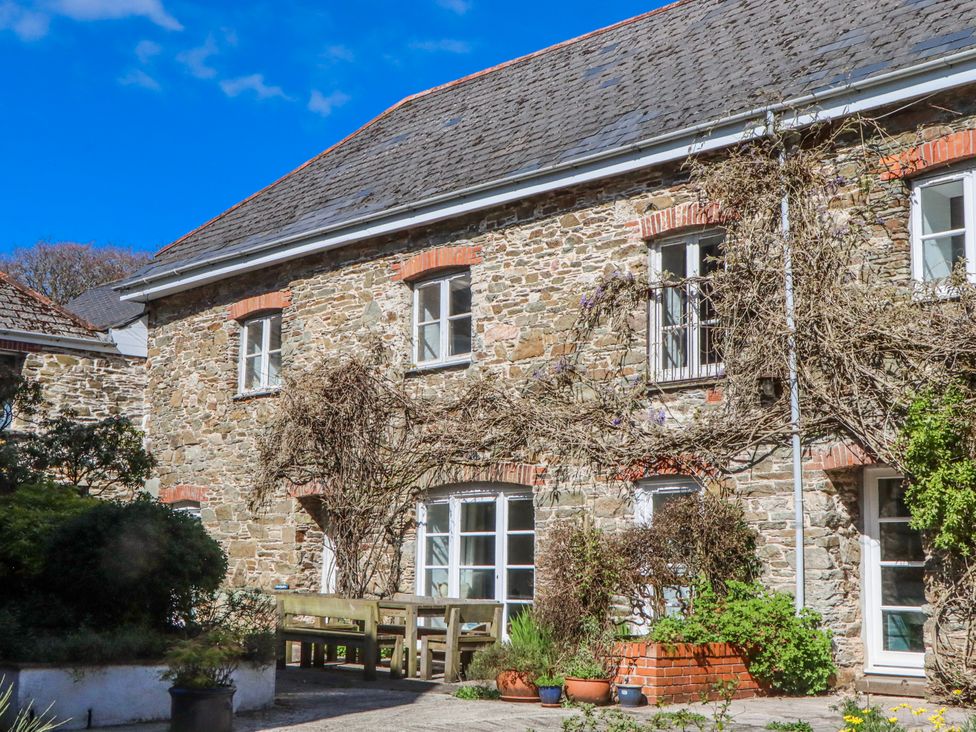 An outdoor area with a stone building and garden at The Barn near Aveton Gifford