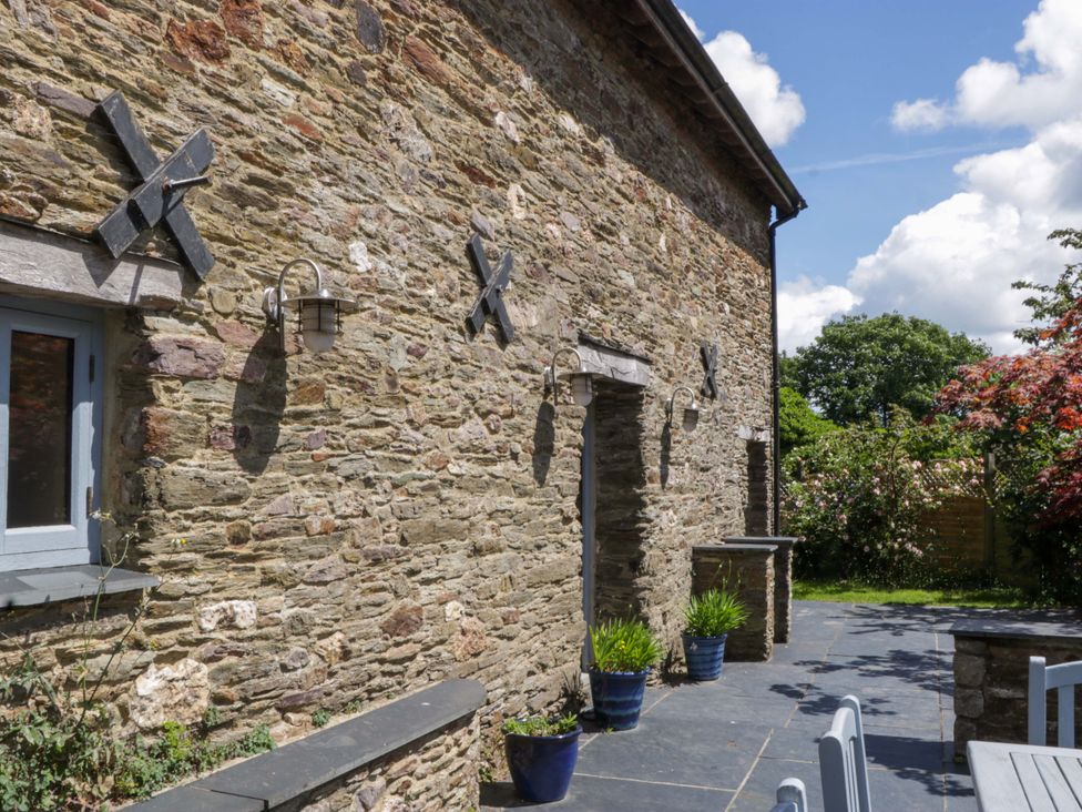 An outdoor wall with stone and window at The Hay Barn in Halwell