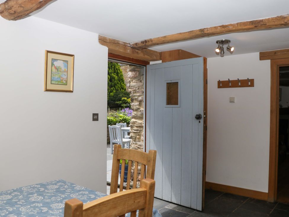 A dining room with a table and chair at The Hay Barn in Halwell