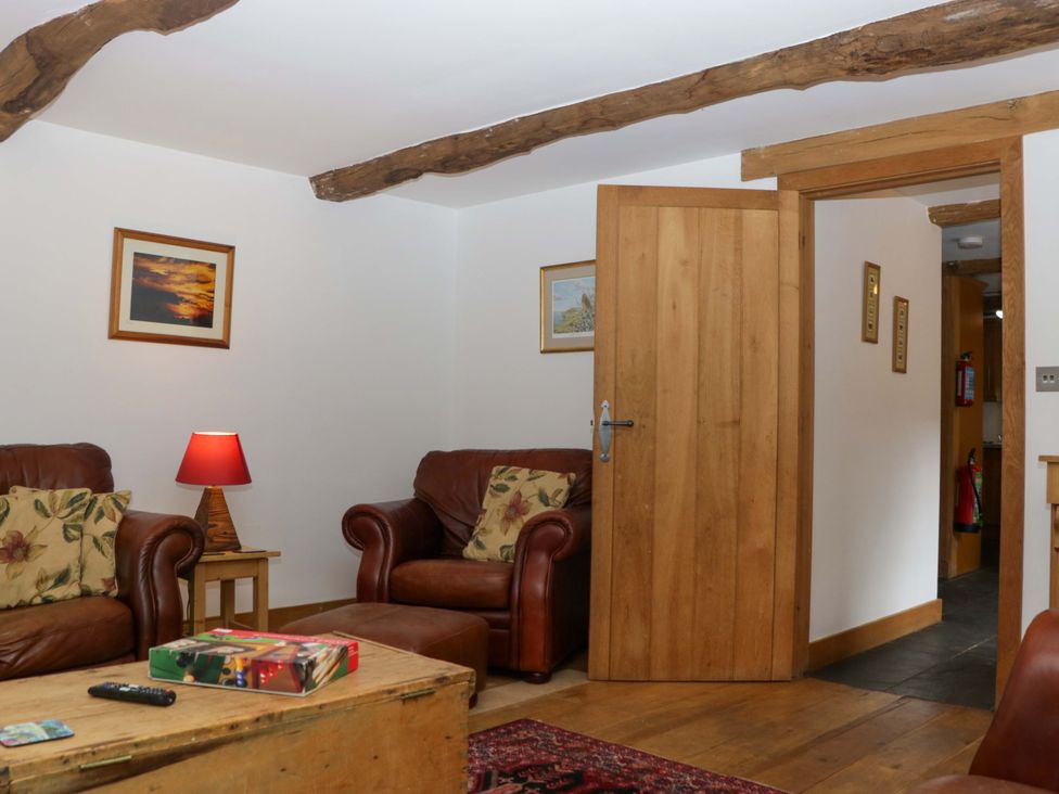 A living room with two sofas and a table at The Hay Barn in Halwell