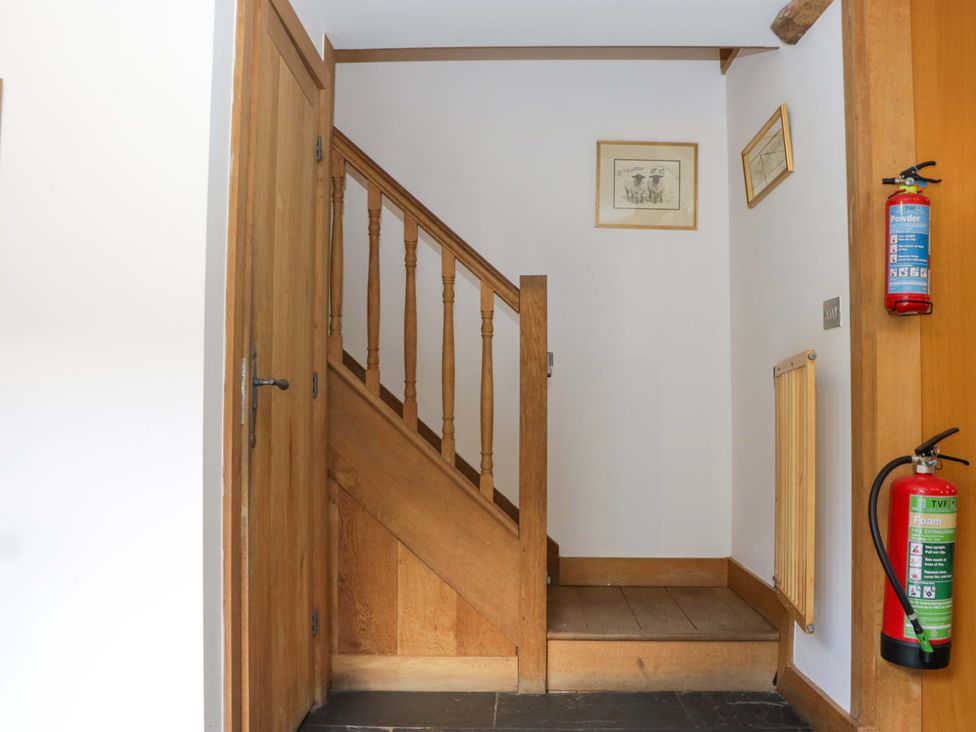 A staircase and a door in a hallway at The Hay Barn in Halwell