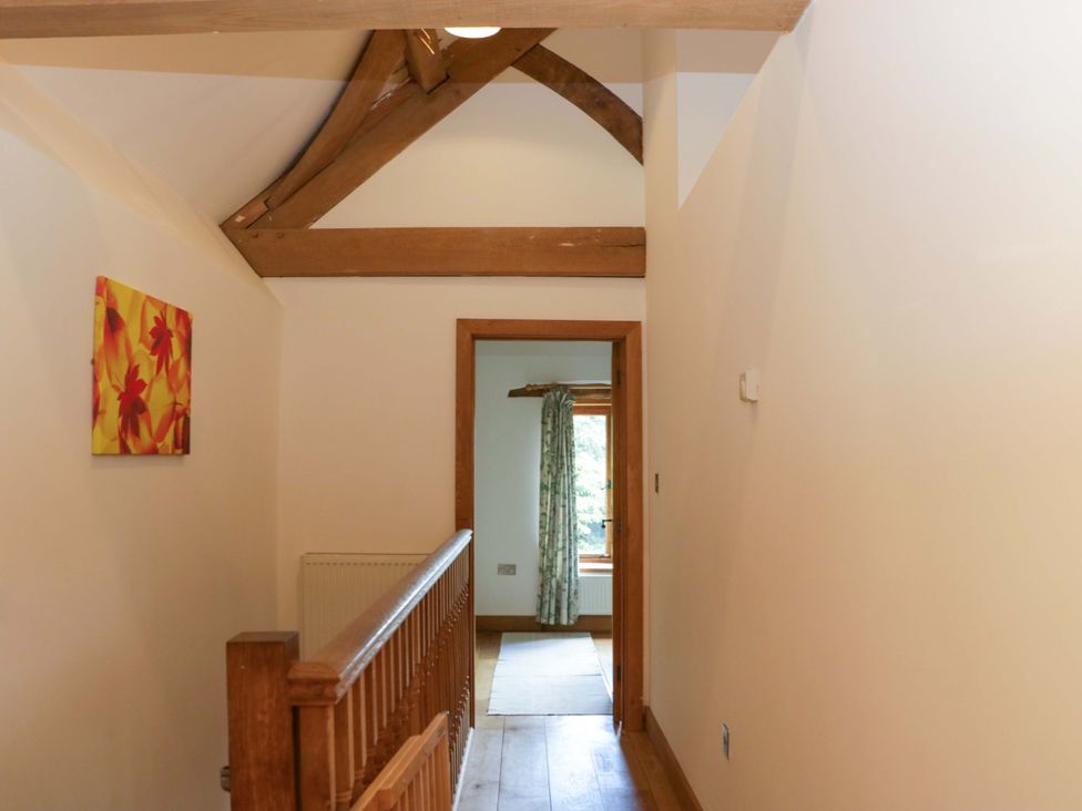 A hallway with wooden features and a view of a window at The Hay Barn in Halwell