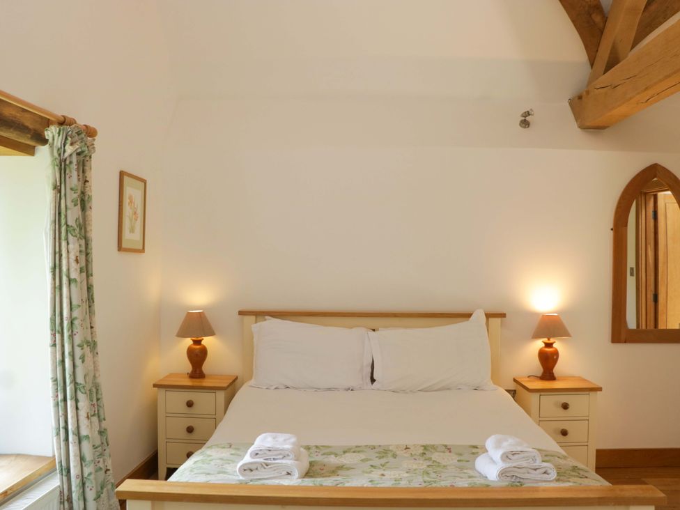 A bedroom with a bed and bedside tables at The Hay Barn Halwell