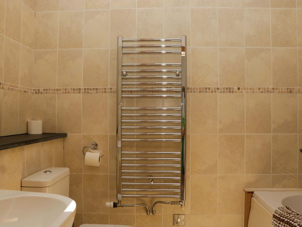 A bathroom with a towel radiator and toilet at The Hay Barn in Halwell