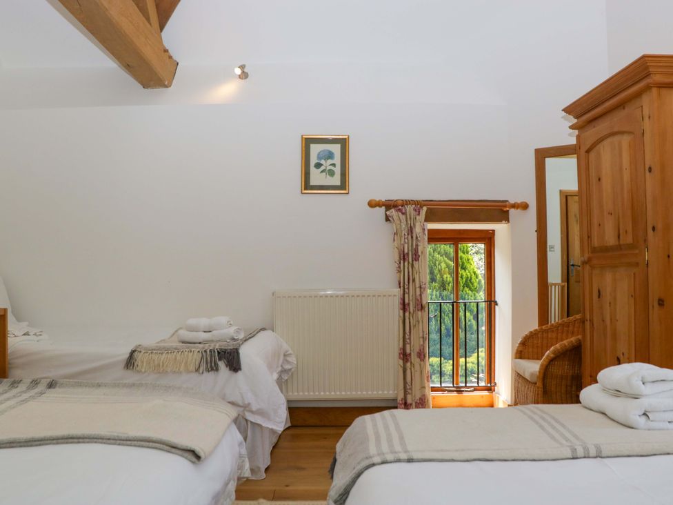A bedroom with two beds and a window at The Hay Barn Halwell