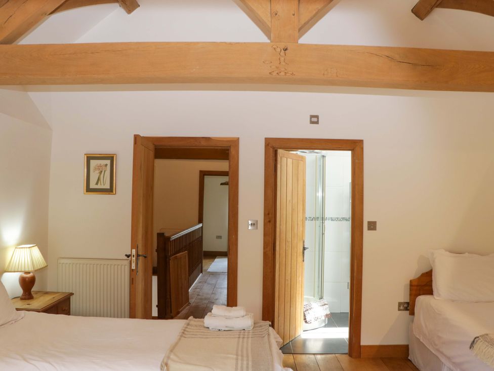 A bedroom with a bed and lamp at The Hay Barn in Halwell