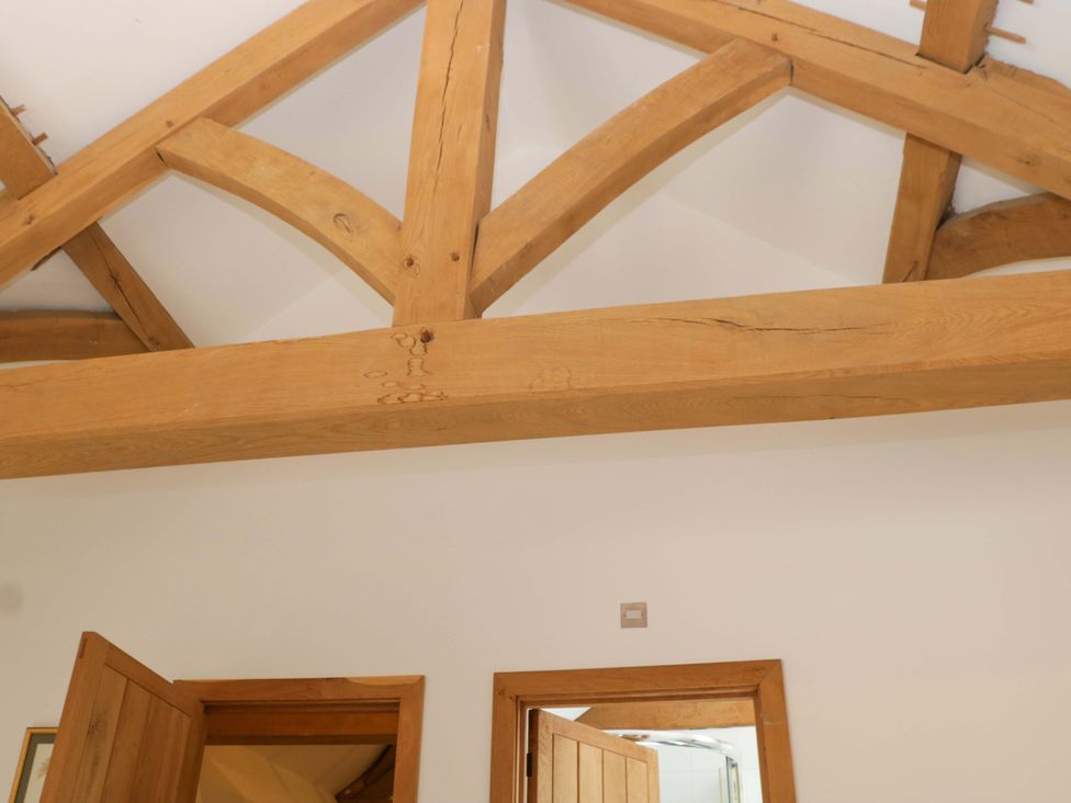 Wooden beams and doors in a room at The Hay Barn Halwell