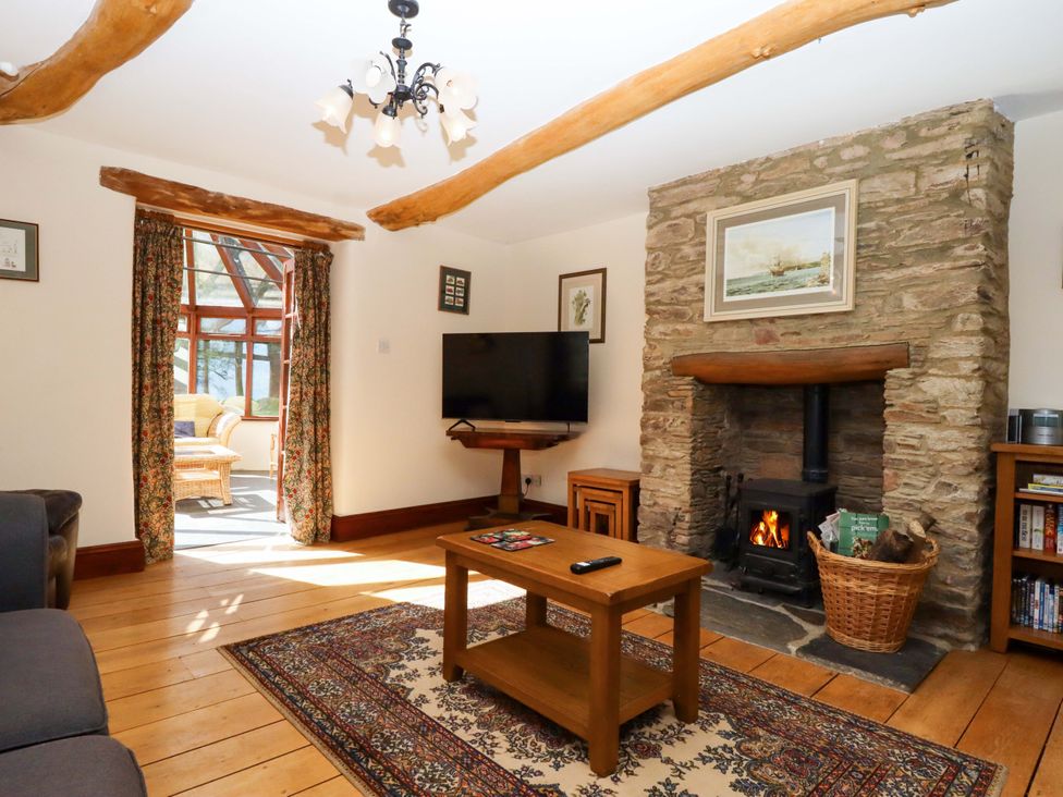 A living room with a fireplace and television at Oak Tree Halwell