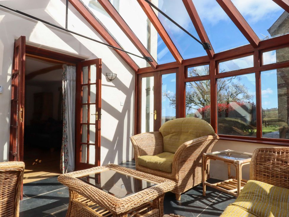 A conservatory with wicker furniture at Oak Tree Halwell
