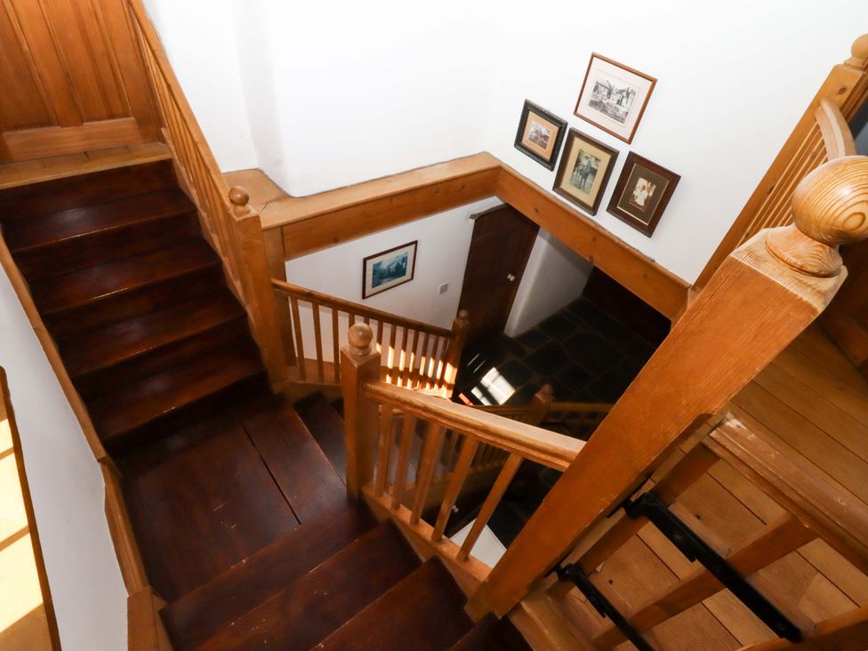A staircase with wooden steps and wall art at Oak Tree Halwell