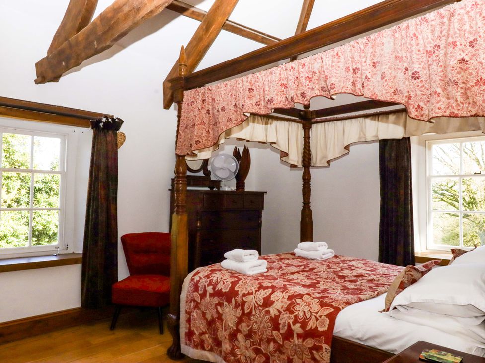 A bedroom with a four-poster bed and a dresser at Oak Tree in Halwell