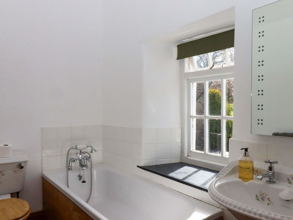 A bathroom with a bathtub, sink, and toilet at Oak Tree in Halwell