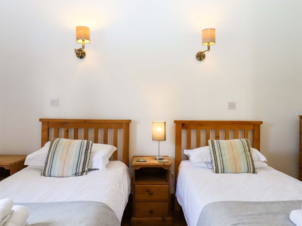 A bedroom with twin beds and lamps at Oak Tree in Halwell
